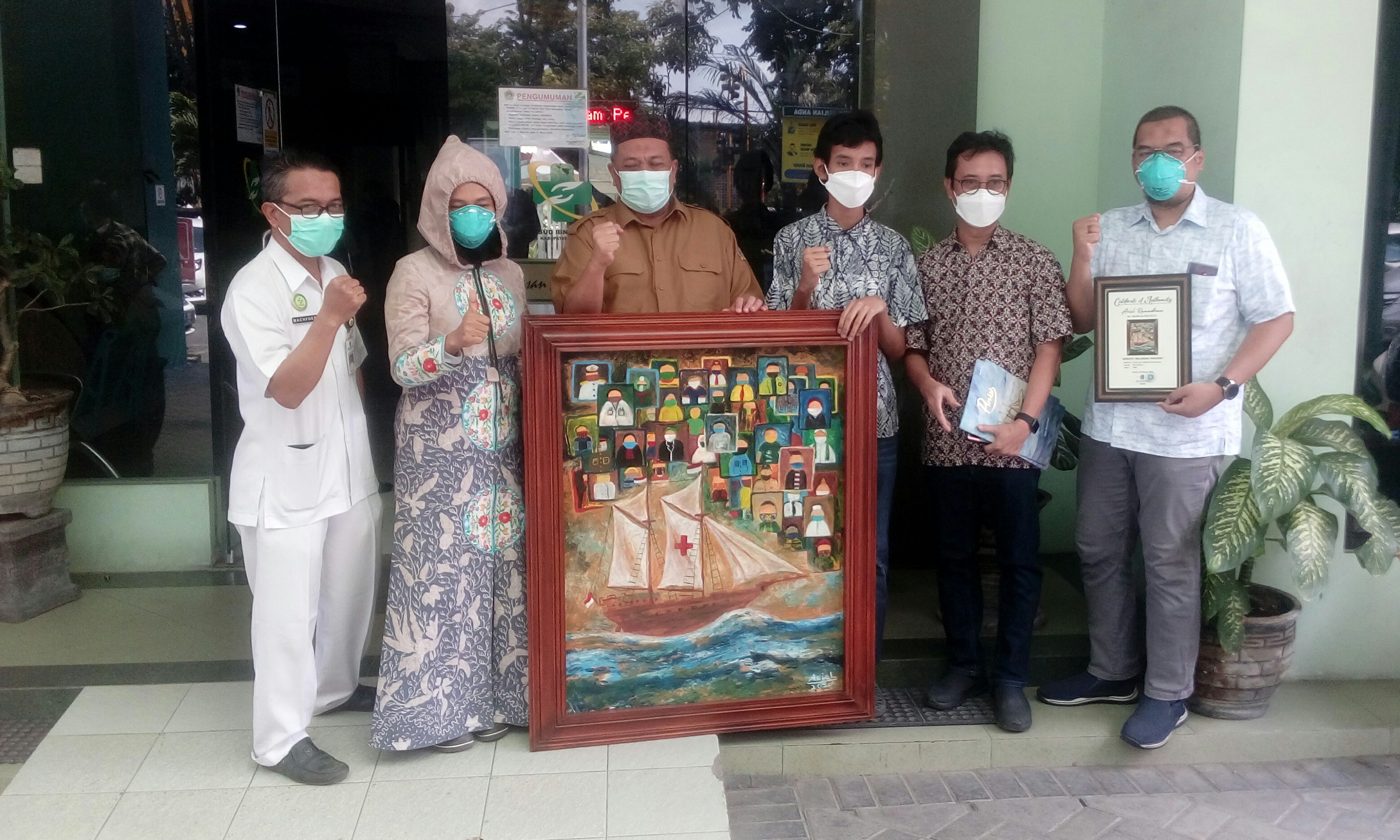 Pelukis muda Ariel Ramadhan saat memberikan karya lukis kepada RSUD Ibnu Sina Gresik