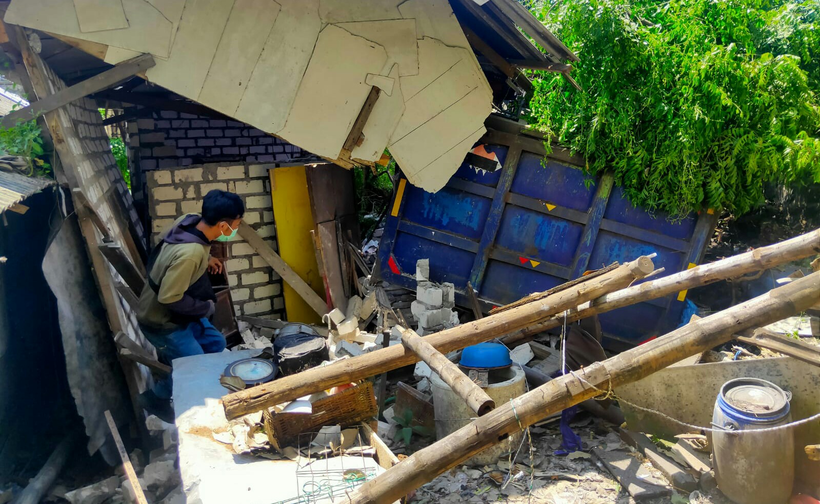 Seorang warga melihat truk bermuatan pasir yang menimpa rumah Syamsuri warga Sumber Jobo Desa Kembangan Kecamatan Kebomas, Kamis (18/3/2021). 