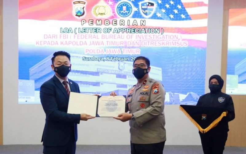 Wakapolda Jatim, Brigjen Pol Slamet Hadi Supraptoyo saat menerima penghargaan dari Legal Attache FBI wilayah Indonesia dan Timor Leste, John Kim. (Polda Jatim)