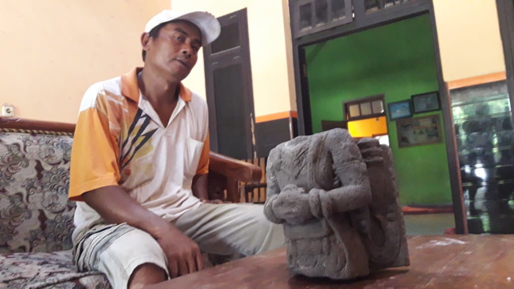 Agus Subagio (42) warga Desa Bangoan, Kecamatan Kedungawaru Tulungagung bersama Arca kuno yang ditemukan