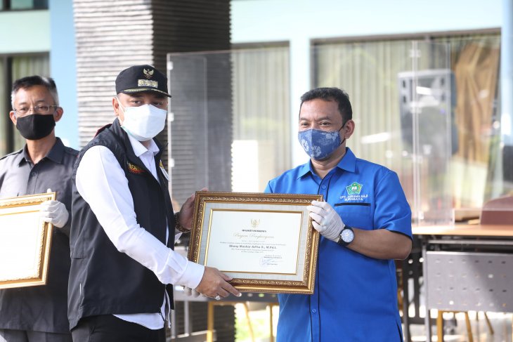 Wali Kota Surabaya Eri Cahyadi saat memberikan piagam penghargaan kepada 93 jajaran UPT Asrama Haji atas penanganan COVID-19 di halaman Asrama Haji, Kota Surabaya, Selasa (29/6/2021)