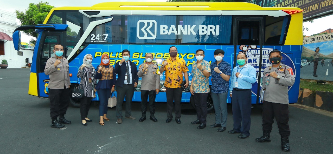 wakapolrestabes Surabaya bersama pihak BRI saat menyerahkan bantuan bus