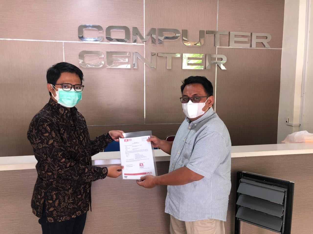 Direktur Direktorat Sistem Informasi (kanan) menyerahkan surat kerja sama dengan Manager IT PLTI (kiri)