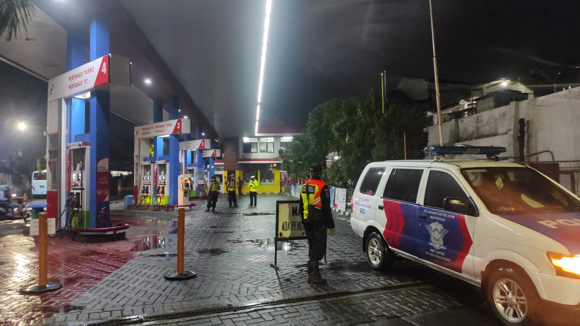 Petugas 3 Pilar saat menertibkan SPBU di Surabaya yang masih tetap beroperasi di malam tahun baru saat pandemi Covid-19, Kamis (31/12/2020) malam.