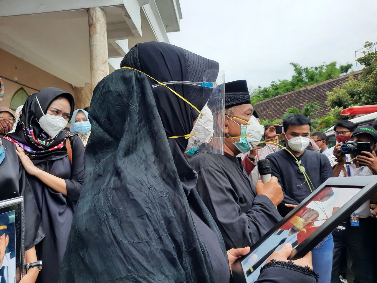 Ninik saat memegang dan memandangi foto anaknya Fadly Satrianto yang jadi korban tragedi pesawat Sriwijaya SJ 182