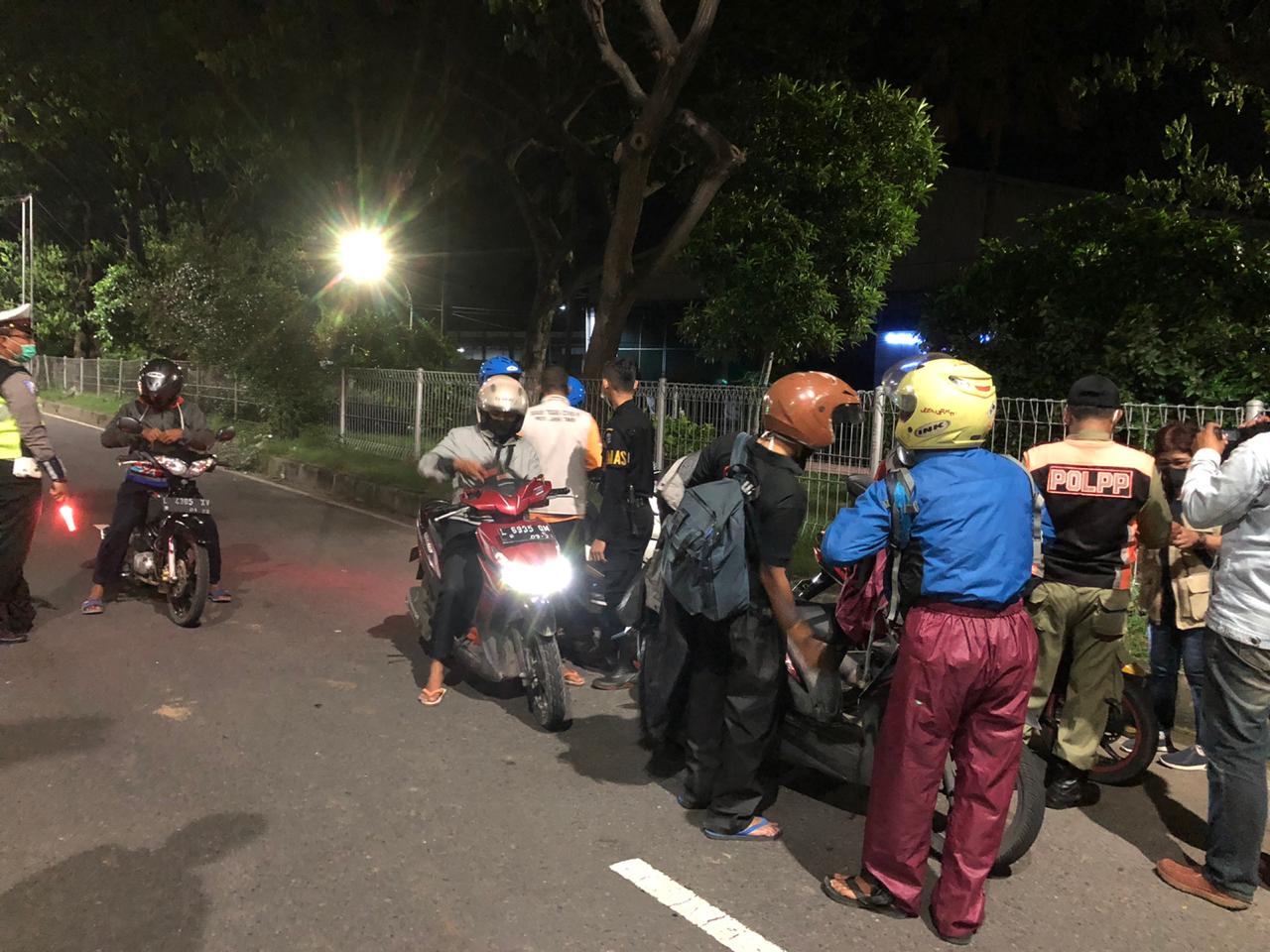 RAZIA: Petugas gabungan saat melakukan pengecekan identitas pengendara motor dari arah Madura menuju Surabaya. |Arry