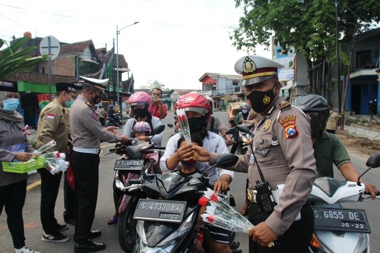 Petugas Satlantas Polres Bojonegoro membagikan bunga bagi pengendara yang tertib lalulintas
