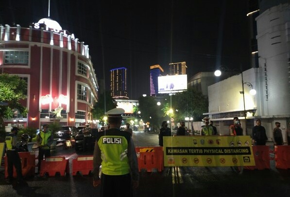 Penyekatan jalan di pusat kota Surabaya pada malam tahun baru dijaga ketat anggota polisi.