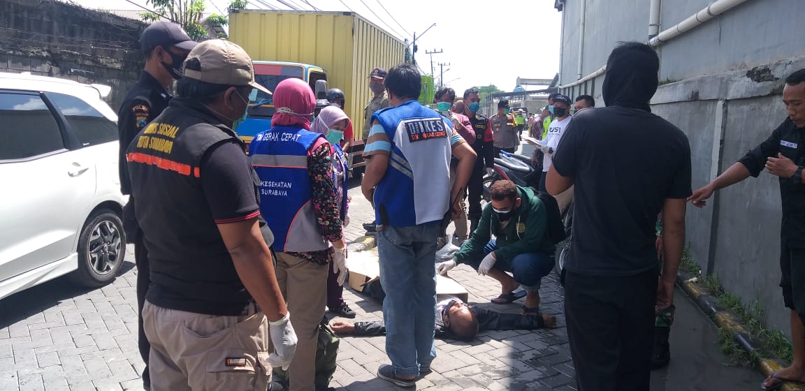 Petugas kepolisian mengevakuasi korban meninggal yang jatuh dari motor di area pergudangan Margomulyo Permai Surabaya, Rabu (23/12/2020)