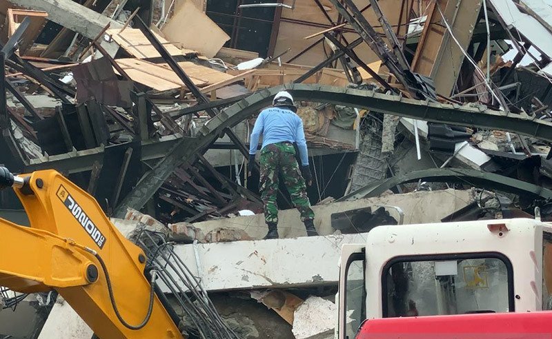 Sejumlah relawan dan anggota TNI berupaya mencari korban di puing-puing bangunan yang ambruk diterjang gempa bumi di Sulawesi Barat.