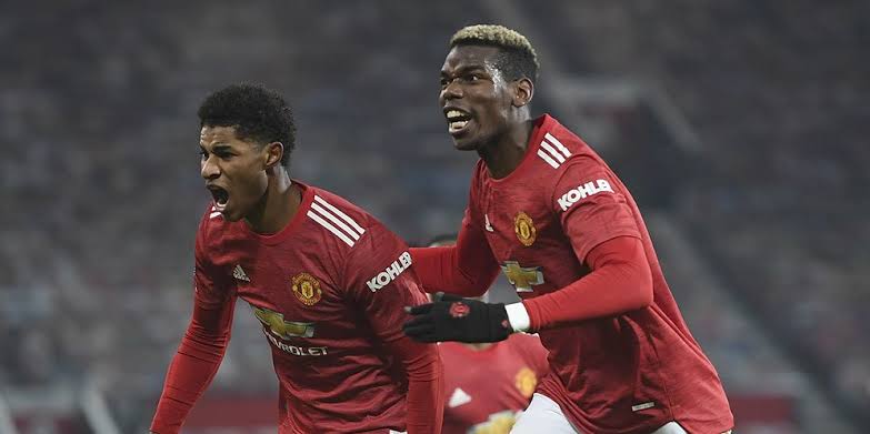 Pemain Manchester United, Marcus Rashford (kiri), merayakan golnya bersama Paul Pogba saat menghadapi Wolverhampton dalam laga lanjutan Premier League Rabu (30/12/2020) lalu (Foto AFP)