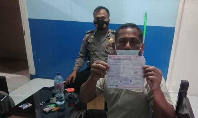 Petugas lantas Polres Mojokerto menunjukkan surat tilang mobil Innova 