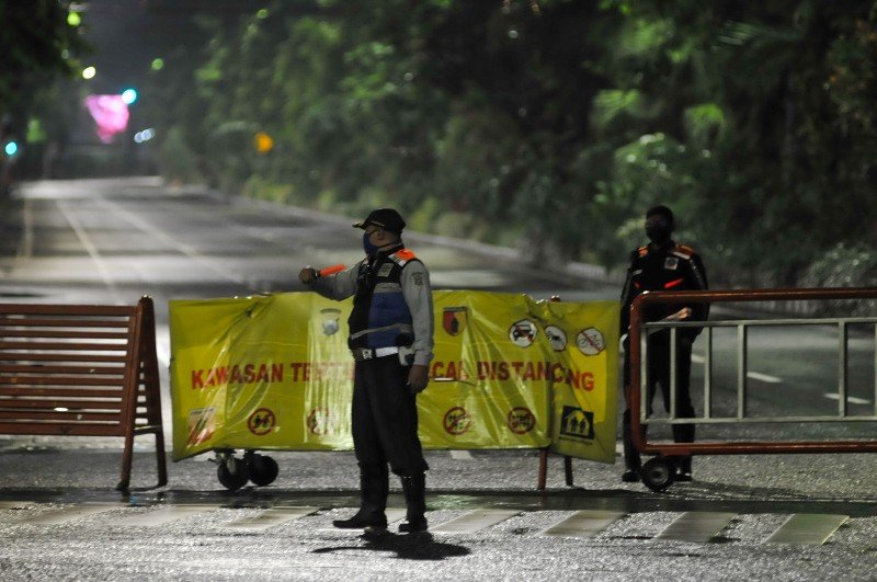 Petugas melakukan penutupan jalan di kawasan Jalan Raya Darmo, Surabaya, Jawa Timur, Jumat (22/1/2021). 
