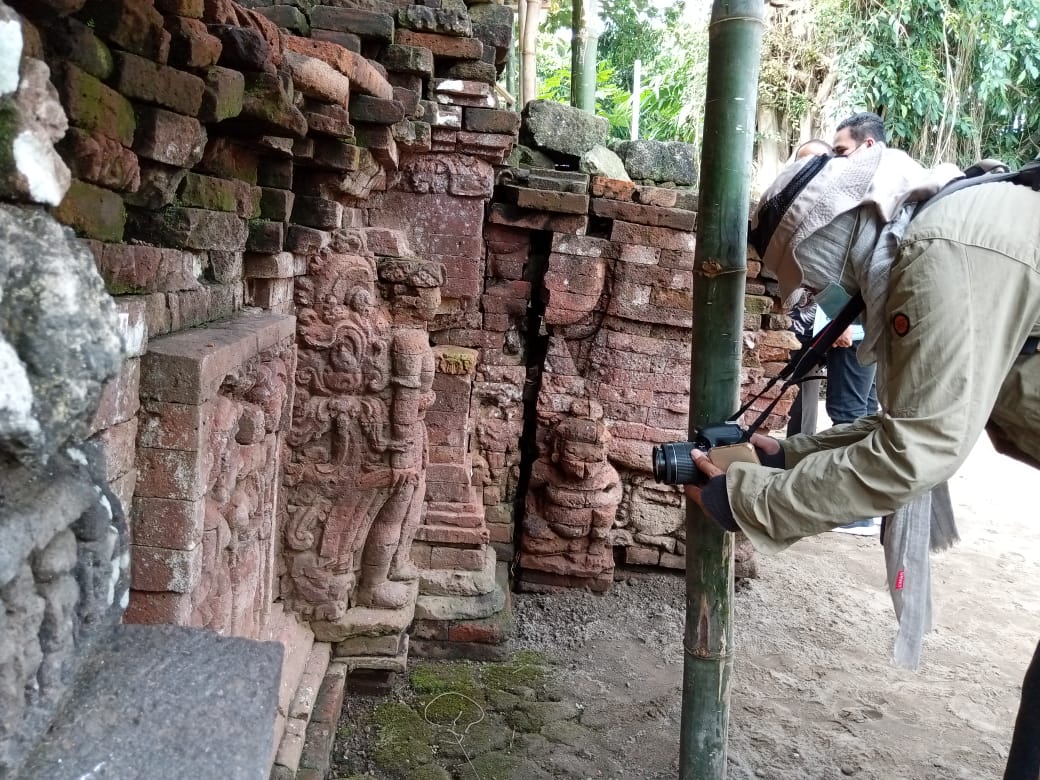 Salah seorang petugas sedang memfoto titik lokasi pemugaran candi di Tulungagung.
