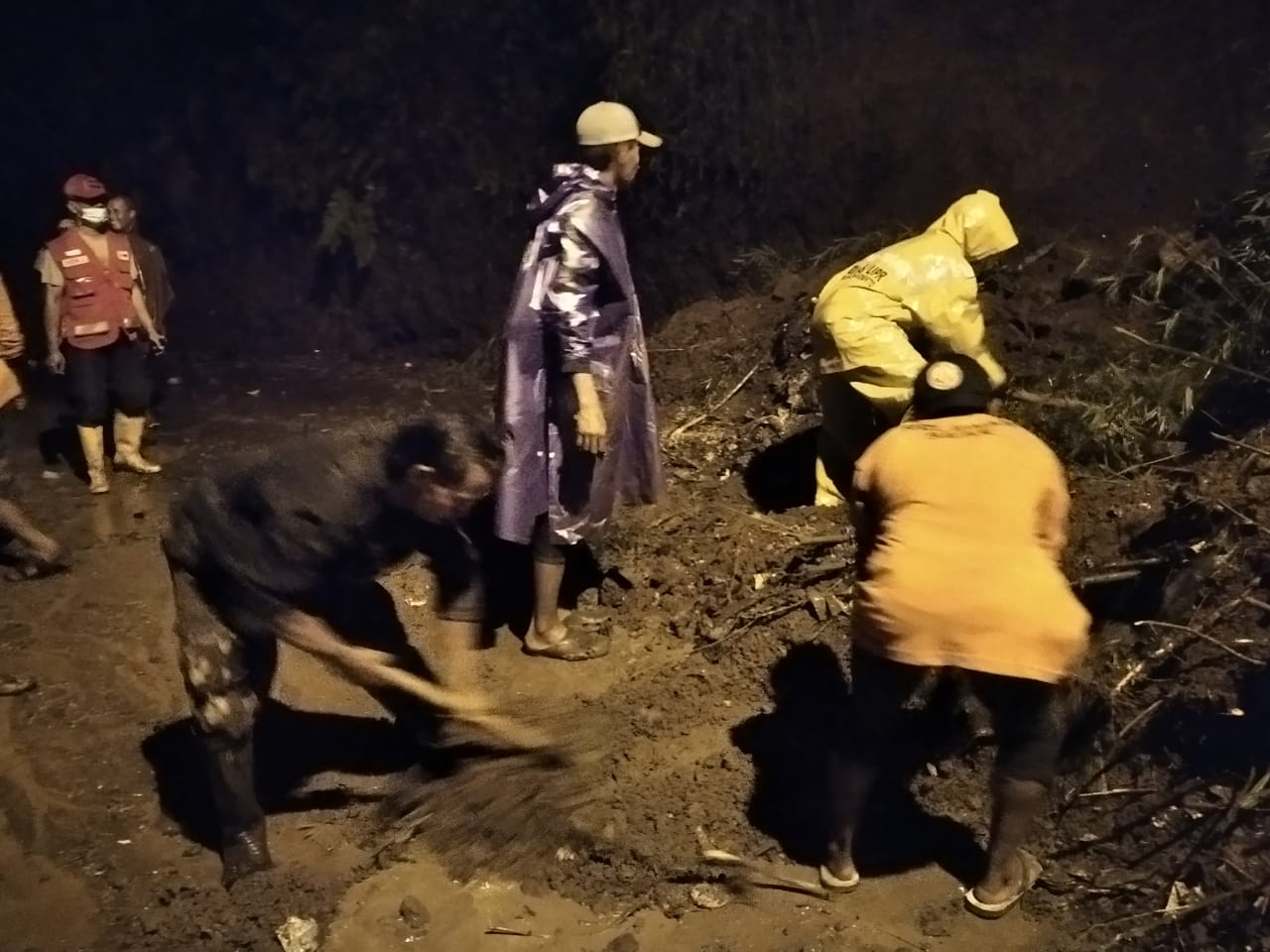 Petugas membersihkan jalan yang tertimbun longsor di Desa Cempoko Limo, Kecamatan Pacet, Mojokerto.
