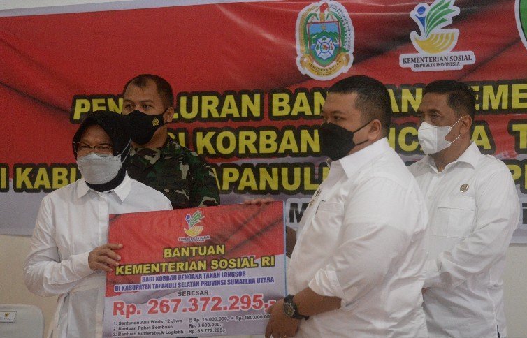 Menteri Sosial Tri Rismaharini (kiri) secara simbolis menyerahkan santunan bernilai total Rp267 juta lebih kepada Bupati Tapanuli Selatan Dolly P.Pasaribu (kanan). | (ant)