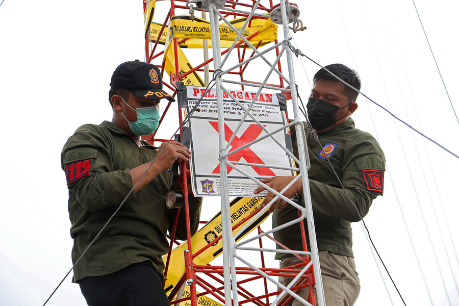 Petugas Satpol PP Surabaya saat menyegel salah satu menara telekomunikasi.