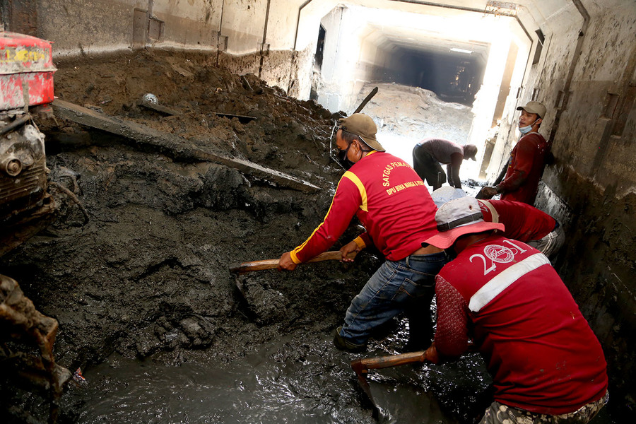 Petugas saat mengeruk saluran box Culvert di Surabaya barat.