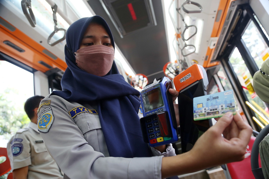 Petugas Dishub menunjukkan cara penggunaan kartu Flazz di Suroboyo Bus. (IST)