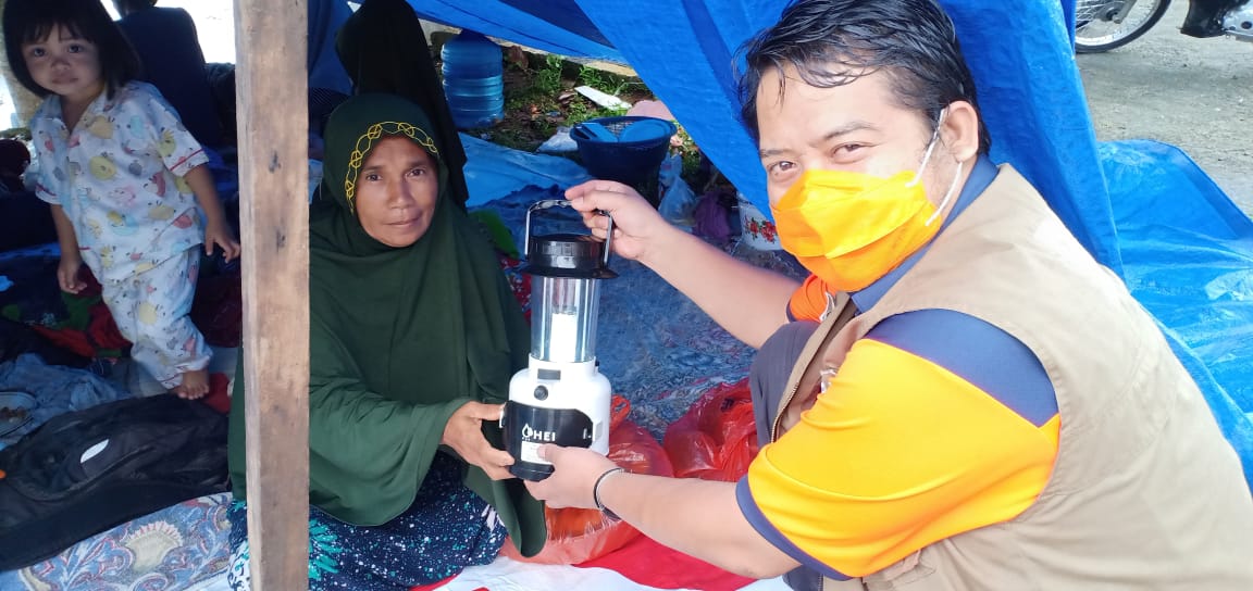 Salah seorang petugas BNPB tampak menyerahkan bantuan kepada korban gempa Sulbar, Senin (18/1/2021).
