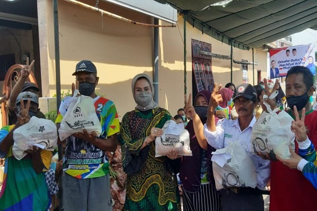 Plt Ketua Partai Demokrat Kota Surabaya, Lucy Kurniasari (pakai batik) sedang membagikan paket bantuan BNPB yang diduga digunakan untuk kampanye