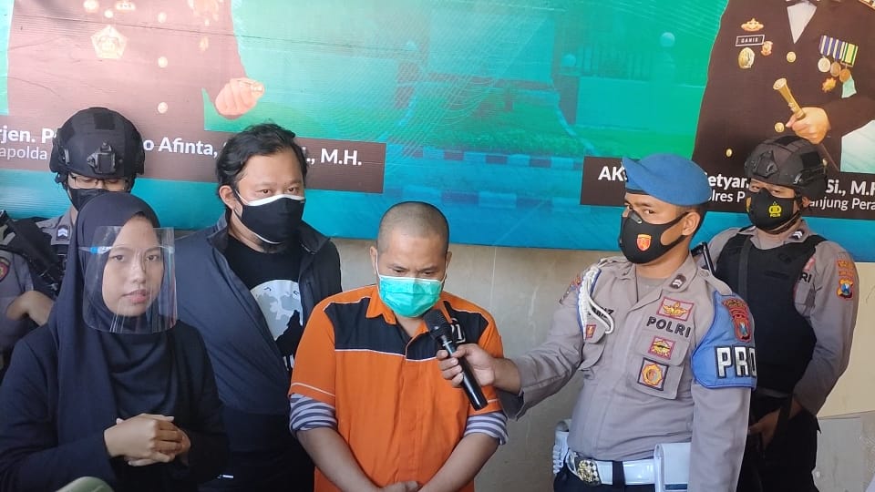 HR diapit anggota Polres Tanjung Perak Surabaya. (Memonews)
